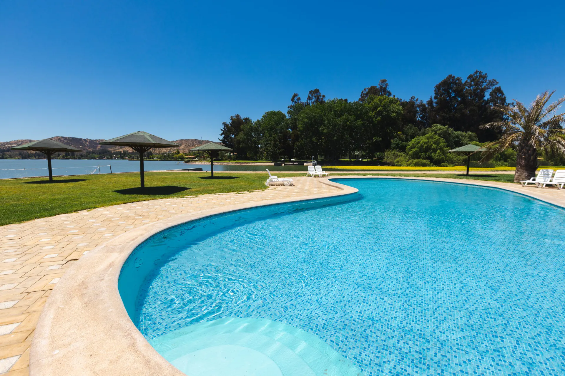 Piscina y áreas verdes de Puerta del Sol frente al Lago Rapel